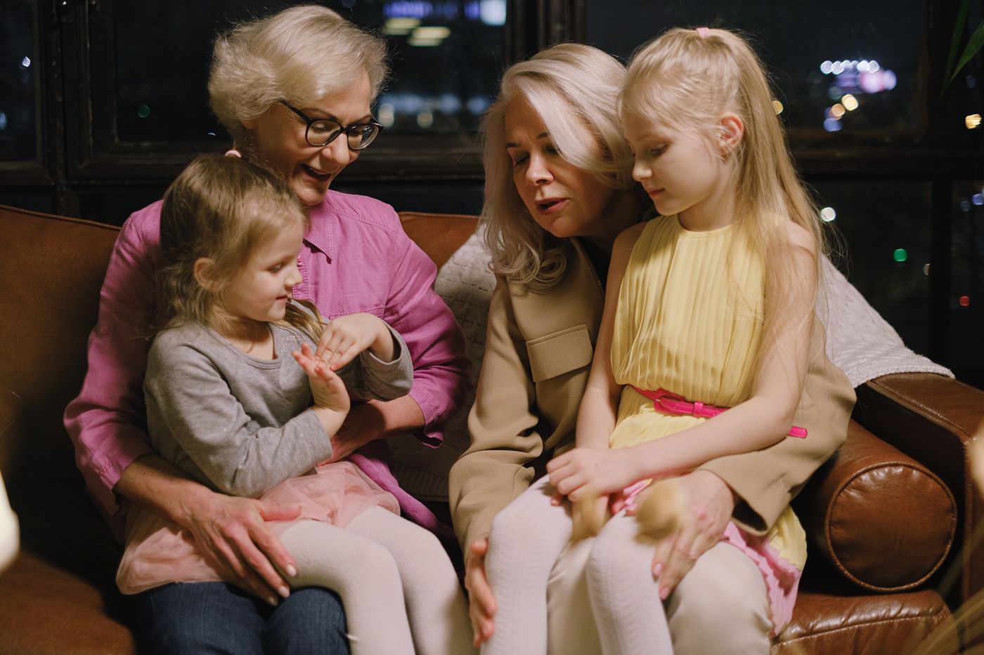 Grandmothers and granddaughters sitting together on a sofa