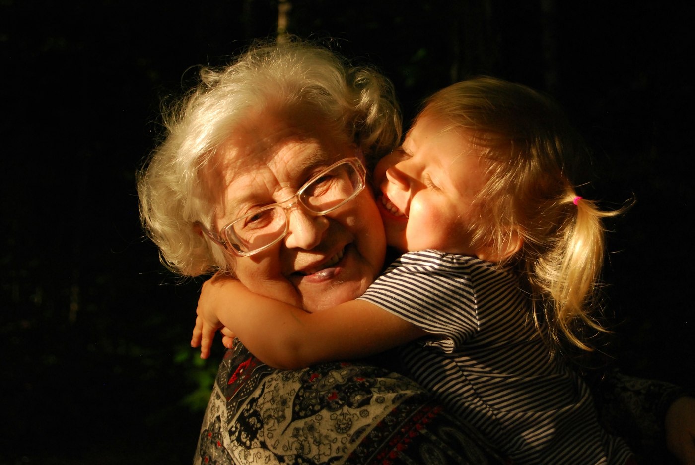 A grandmother hugging her granddaughter